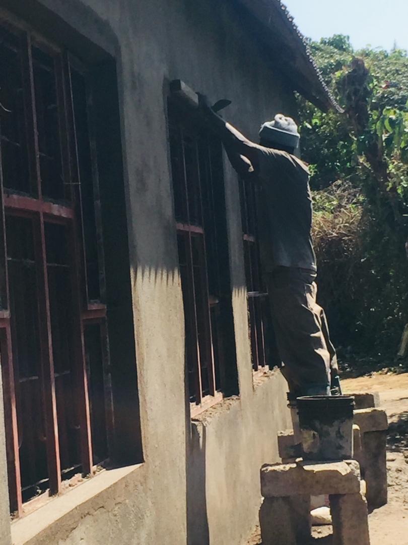 man working on outside of school building